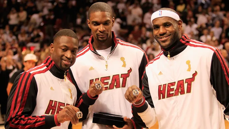 (L) Dwyane Wade #3 of the Miami Heat, (C) Chris Bosh #1 of the Miami Heat and (R) LeBron James #6 of the Miami Heat pose with their 2012 NBA Championship rings prior to the game against the Boston Celtics at American Airlines Arena on October 30, 2012 in Miami, Florida.