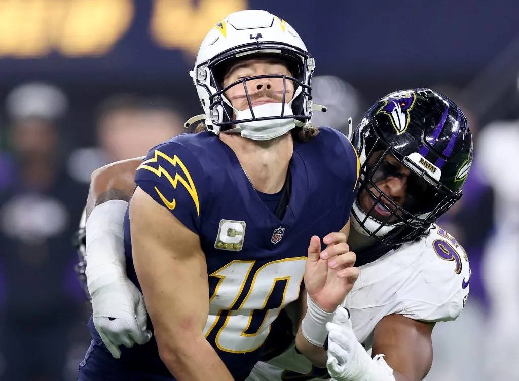 Tavius Robinson #95 of the Baltimore Ravens tackles Justin Herbert #10 of the Los Angeles Chargers