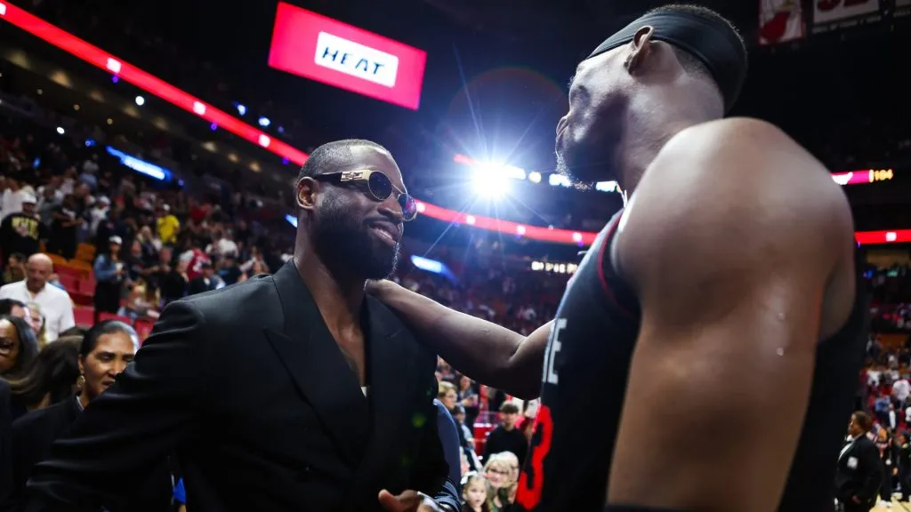 Former Miami Heat player Dwayne Wade and Bam Adebayo #13 of the Heat embrace on the court after a game against the Charlotte Hornets at Kaseya Center on January 14, 2024 in Miami, Florida. 
