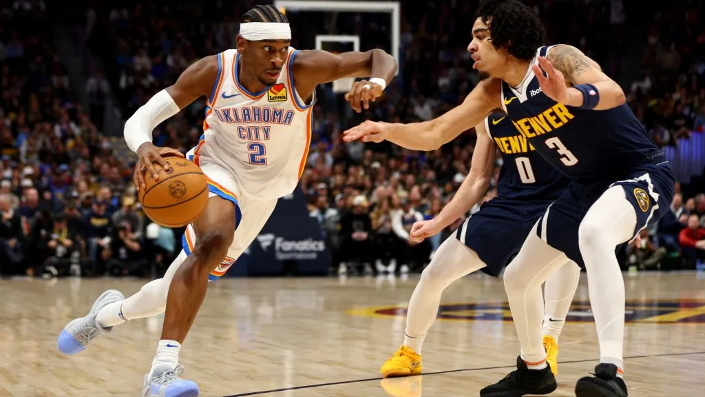 Shai Gilgeous-Alexander #2 of the Oklahoma City Thunder drives past Julian Strawther #3 of the Denver Nuggets in the second half at Ball Arena. Jamie Schwaberow/Getty Images
