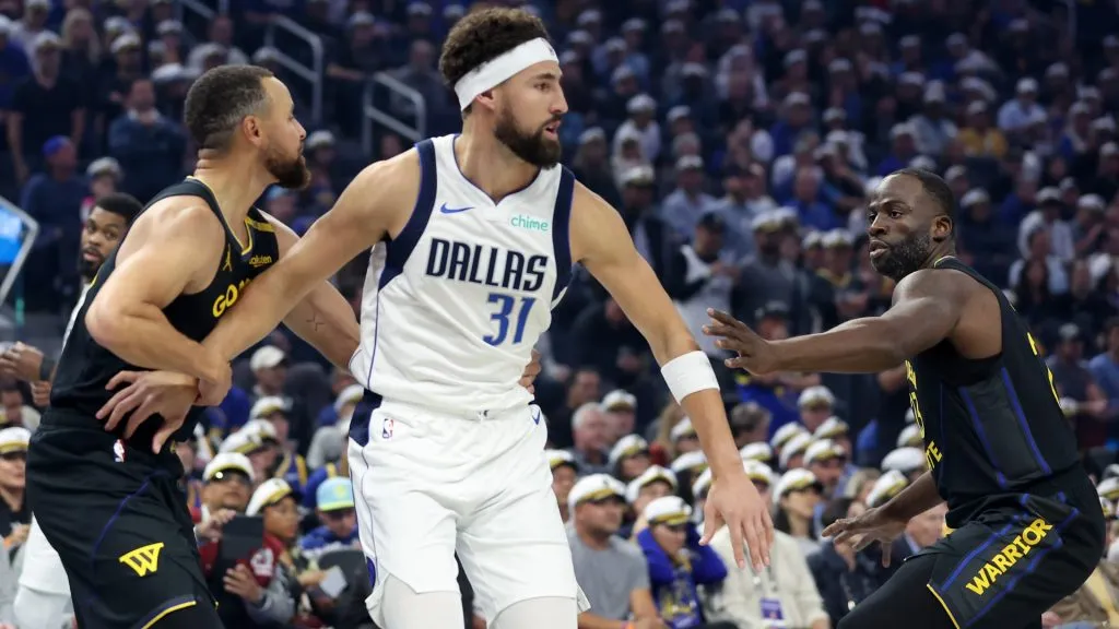 Klay Thompson #31 of the Dallas Mavericks is guarded by former teammates Draymond Green #23 and Stephen Curry #30 of the Golden State Warriors before their game at Chase Center on November 12, 2024 in San Francisco, California.   (Photo by Ezra Shaw/Getty Images)
