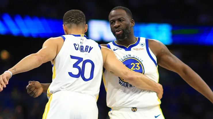 Stephen Curry #30 and Draymond Green #23 of the Golden State Warriors shake hands during a game against the Orlando Magic at Kia Center on March 27, 2024 in Orlando, Florida.