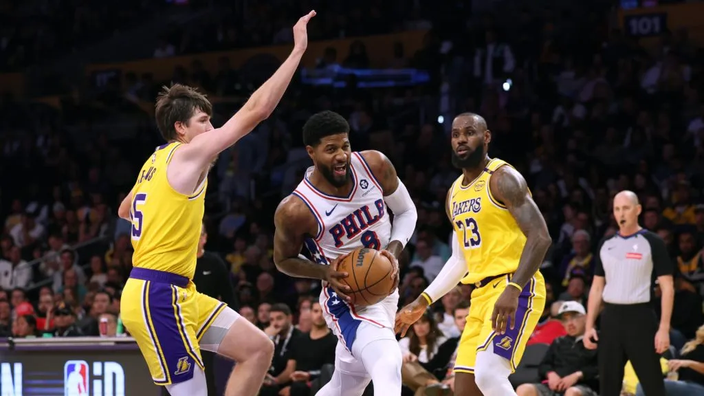 Paul George #8 of the Philadelphia 76ers drives to the basket between Austin Reaves #15a and LeBron James #23 of the Los Angeles Lakers during a 116-106 Lakers win at Crypto.com Arena. Harry How/Getty Images