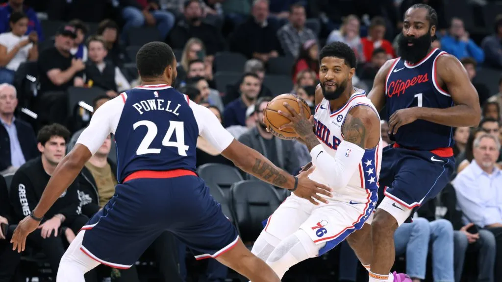 Paul George #8 of the Philadelphia 76ers dribbles between James Harden #1 and Norman Powell #24 of the LA Clippers during a 110-98 LA Clippers win at Intuit Dome. Harry How/Getty Images