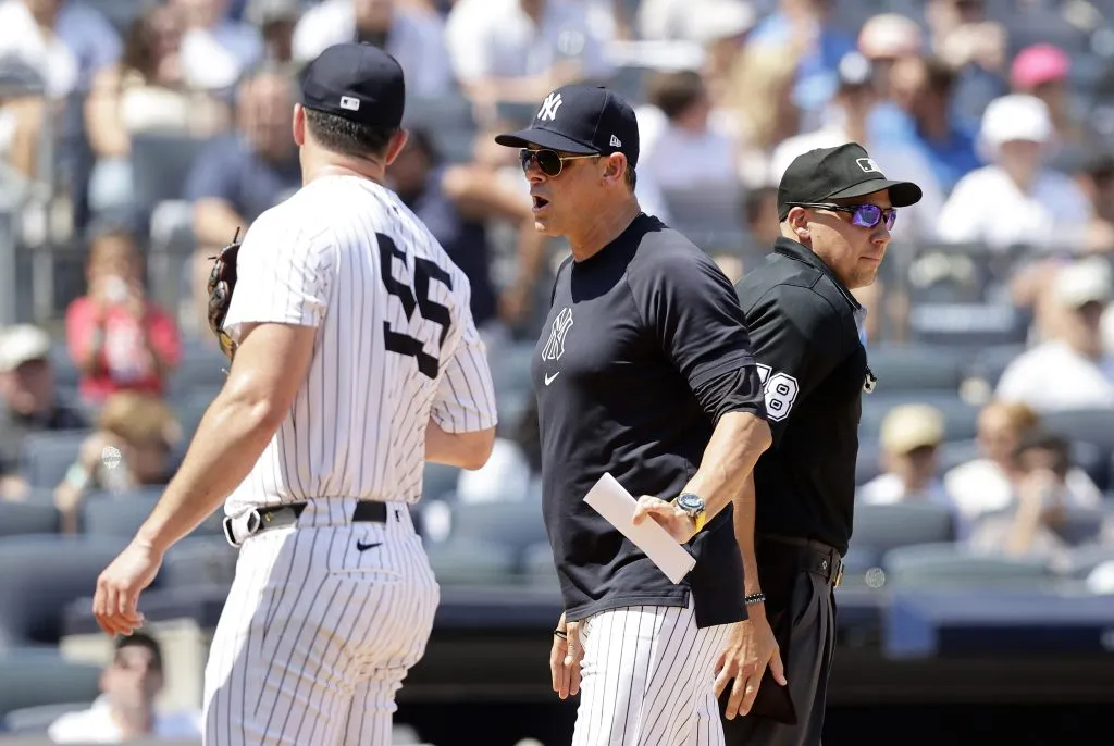 Manager Aaron Boone #17 of the New York Yankees gets in between Carlos Rodon #55