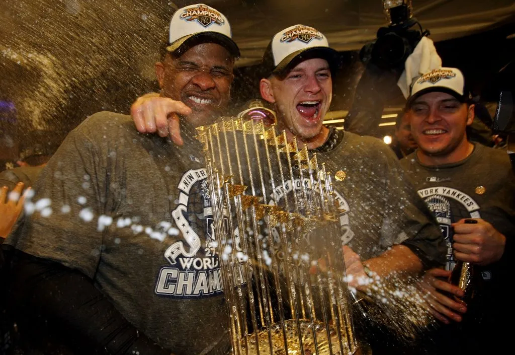 NEW YORK – NOVEMBER 04:  (L-R) C.C. Sabthia #52, A.J. Burnett #34 and Eric Hinske #14 of the New York Yankees celebrate with the trophy in the locker room after their 7-3 win against the Philadelphia Phillies in Game Six of the 2009 MLB World Series at Yankee Stadium on November 4, 2009 in the Bronx borough of New York City.  (Photo by Nick Laham/Getty Images)