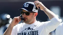 Interim head coach Nate Dreiling of the Utah State Aggies talks on his headset during the first half of their game against the Utah Utes at Maverik Stadium on September 14, 2024 in Logan, Utah.