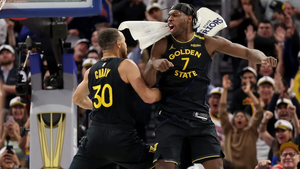 Stephen Curry #30 and Buddy Hield #7 of the Golden State Warriors react after Curry made a three-point basket in the final minute of their game against the Dallas Mavericks at Chase Center. (Ezra Shaw/Getty Images)