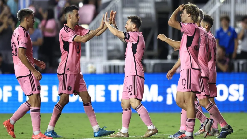 Lionel Messi #10 of Inter Miami celebrates with Sergio Busquets #5 after scoring his second goal during the second half against the New England Revolution at Chase Stadium. (Carmen Mandato/Getty Images)