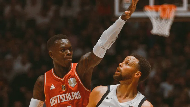 Stephen Curry of USA attempts a three point shot over Dennis Schröder of Germany during a game.