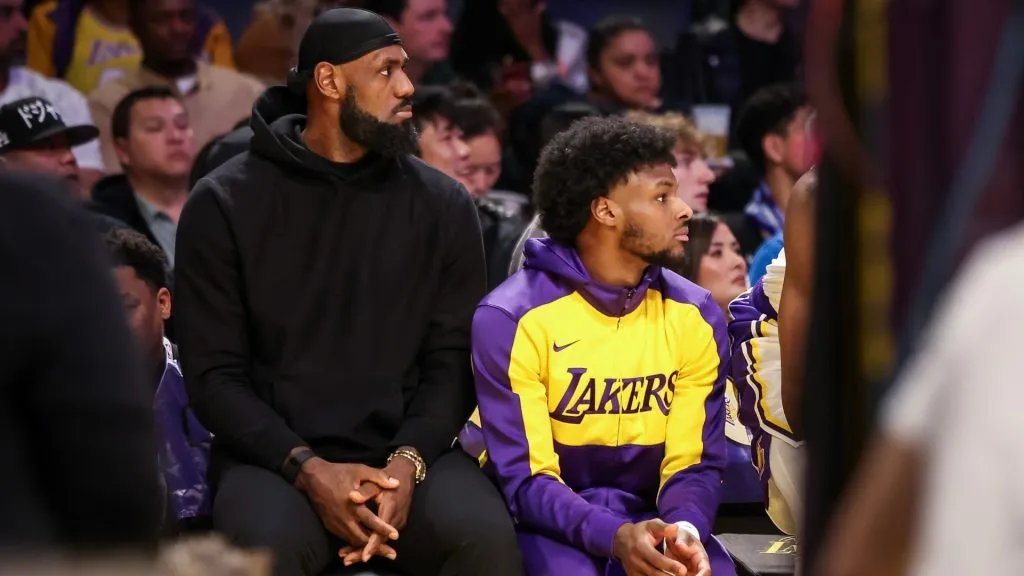 LeBron James #23 and Bronny James #9 of the Los Angeles Lakers look on from the bench in the first half against the Portland Trail Blazers at Crypto.com Arena on December 08, 2024 in Los Angeles, California. (Photo by Meg Oliphant/Getty Images)
