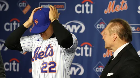 David Stearns, the president of baseball operations for the New York Mets fits Juan Soto with his New York Mets jersey as his agent Scott Boras watches during his introductory press conference at Citi Field on December 12, 2024 in New York City.