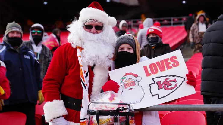 A Kansas City Chiefs fan, dressed as Santa Claus, poses for a photo with a fan before their game against the Seattle Seahawks.