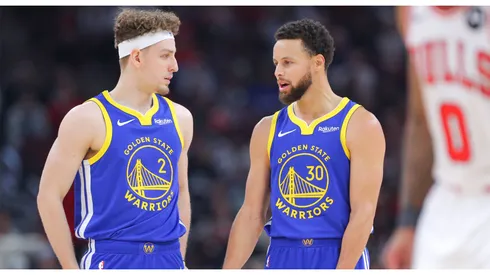 Brandin Podziemski 2 of the Golden State Warriors chats with Stephen Curry 30 of the Golden State Warriors during the first half against the Chicago Bulls at the United Center on January 12, 2024 in Chicago, Illinois.