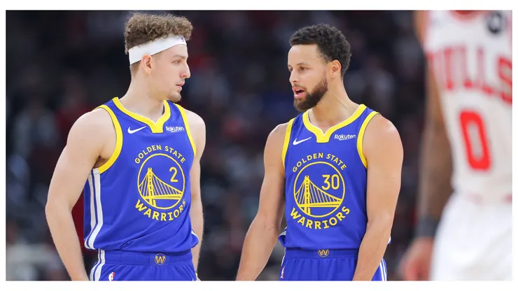 Brandin Podziemski 2 of the Golden State Warriors chats with Stephen Curry 30 of the Golden State Warriors during the first half against the Chicago Bulls at the United Center on January 12, 2024 in Chicago, Illinois.