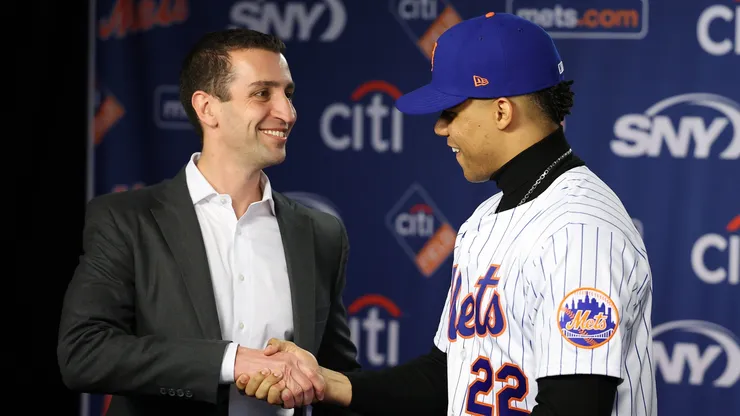 David Stearns, the president of baseball operations for the New York Mets fits Juan Soto with his New York Mets jersey, during his introductory press conference at Citi Field on December 12, 2024 in New York City.
