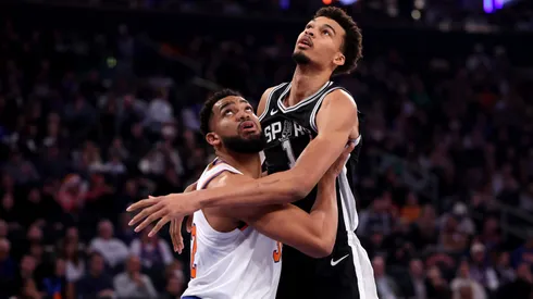 Karl-Anthony Towns #32 of the New York Knicks and Victor Wembanyama #1 of the San Antonio Spurs battle for a rebound during the first quarter at Madison Square Garden.