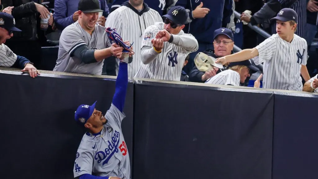 Fans Austin Capobianco (L) and John Peter (R) interfere with Mookie Betts #50 of the Los Angeles Dodgers as he attempts to catch a fly ball in foul territory during the first inning of Game Four of the 2024 World Series against the New York Yankees at Yankee Stadium on October 29, 2024 in the Bronx borough of New York City. The play resulted in an out. (Photo by Al Bello/Getty Images)