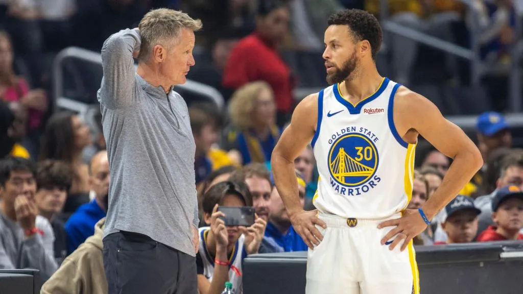 Steve Kerr talks with Stephen Curry courtside during a break in the first half of a game between the Golden State Warriors and Los Angeles Clippers. (IMAGO / Icon Sportswire)