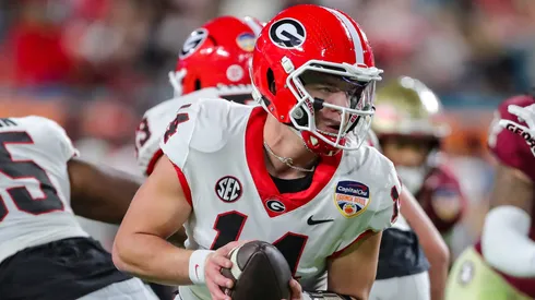 Georgia Bulldogs quarterback Gunner Stockton (14) turns to hand the ball off during the second half of the Capital One Orange Bowl between the University of Georgia Bulldogs and the Florida State University Seminoles at Hard Rock Stadium in Miami Gardens, FL.