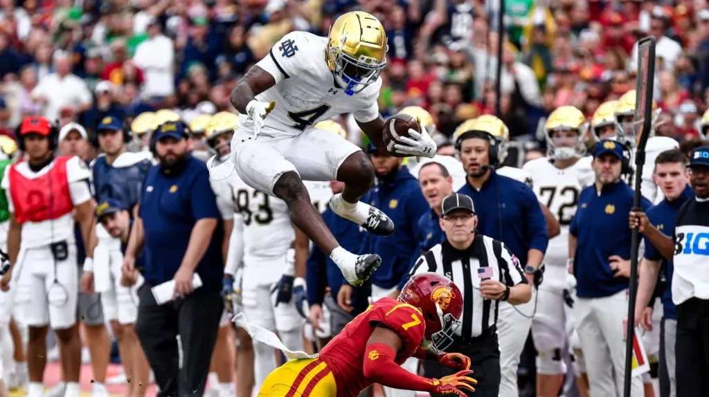 Notre Dame Fighting Irish running back Jeremiyah Love (4) hurdles USC Trojans safety Kamari Ramsey (7) on the run in action in the second quarter during the NCAA Football game between the Notre Dame Fighting Irish and the USC Trojans at the Coliseum in Los Angeles, California.
