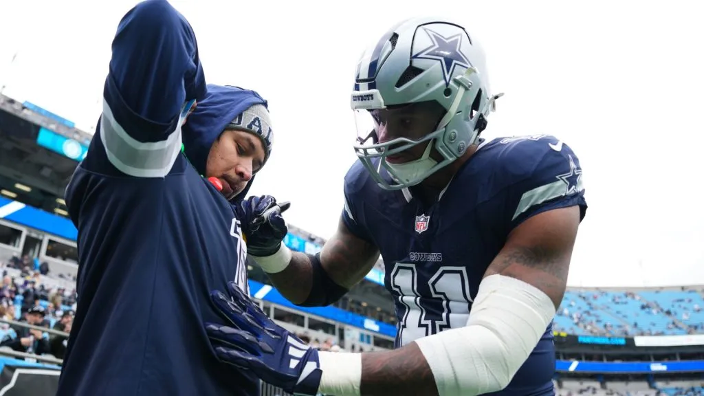 Micah Parsons #11 of the Dallas Cowboys signs a jersey for a fan before the game against the Carolina Panthers at Bank of America Stadium on December 15, 2024. (Source: Grant Halverson/Getty Images)