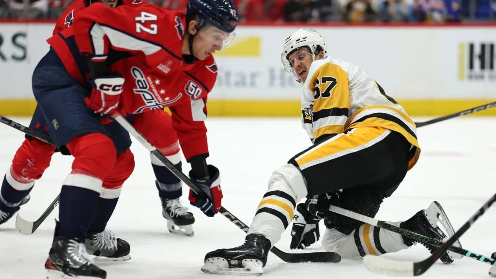 Rickard Rakell #67 of the Pittsburgh Penguins falls to the ice in front of Martin Fehervary #42 of the Washington Capitals during the first period at Capital One Arena on November 08, 2024. (Source: Patrick Smith/Getty Images)