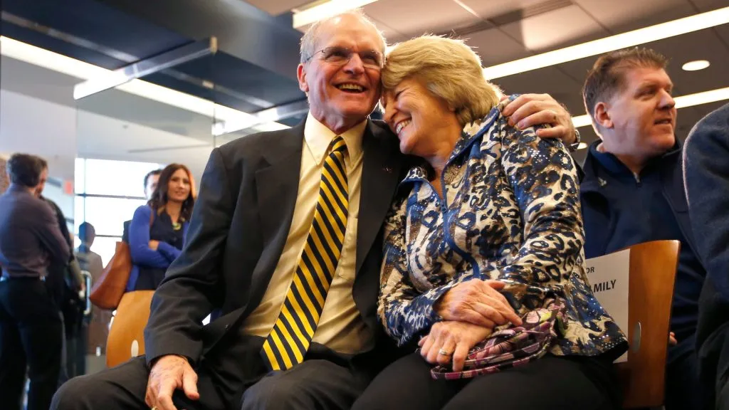 Jack Harbaugh (L) and Jackie Harbaugh, parents of Jim Harbaugh, enter the press conference to introduce Jim Harbaugh as the new Head Coach of the University of Michigan football team in 2014. (Source: Gregory Shamus/Getty Images)