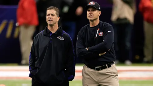 Head coach John Harbaugh of the Baltimore Ravens (L) and head coach Jim Harbaugh of the San Francisco 49ers speak during warm ups prior to Super Bowl XLVII.