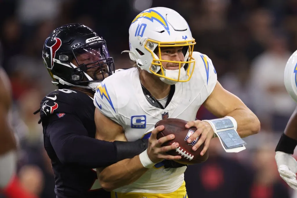 Denico Autry #96 of the Houston Texans sacks Justin Herbert #10 of the Los Angeles Chargers