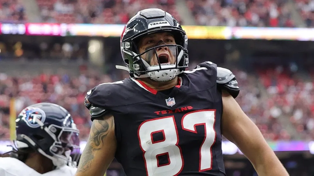 Cade Stover #87 of the Houston Texans scores a touchdown against Jerome Baker #17 of the Tennessee Titans at NRG Stadium on November 24, 2024 in Houston, Texas.
