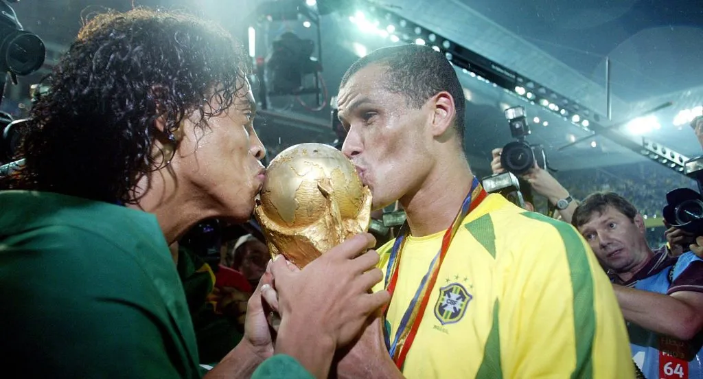 Brazil players Ronaldinho and Rivaldo kiss the World Cup trophy after beating Germany in the final. Yokohama, Japan, June 30, 2002.