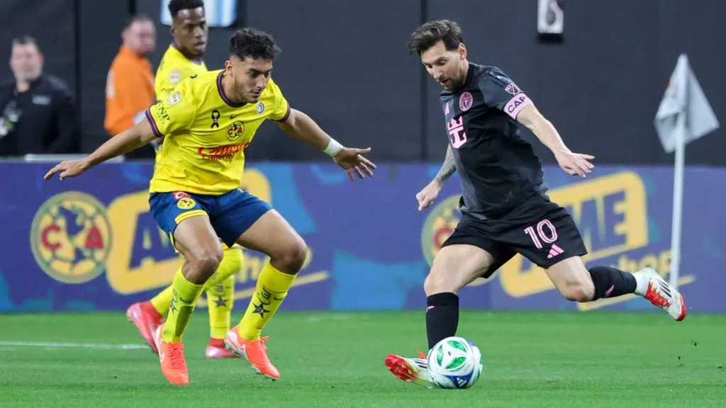 Lionel Messi #10 of Inter Miami CF kicks the ball under pressure from Sebastian Caceres #4 of America in the first half of their preseason friendly match. (Ethan Miller/Getty Images)