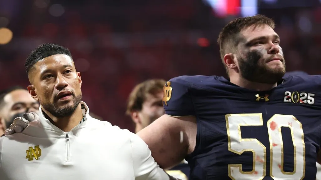 Head coach Marcus Freeman and offensive lineman #50 Rocco Spindler of the Notre Dame Fighting Irish look on after losing to the Ohio State Buckeyes 34-23 in the 2025 CFP National Championship at the Mercedes-Benz Stadium on January 20, 2025 in Atlanta, Georgia.