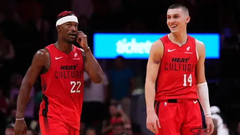 Jimmy Butler #22 and Tyler Herro #14 of the Miami Heat react against the Dallas Mavericks during overtime at Kaseya Center.