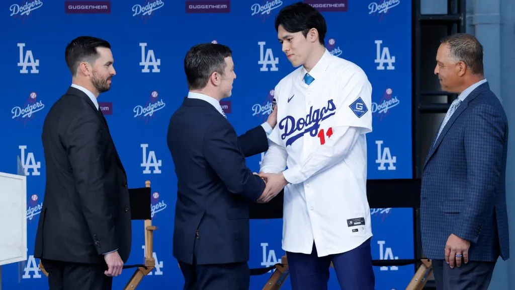 Pitcher Roki Sasaki (2R) shakes hands with President, Baseball Operations Andrew Friedman (2L) talk during a Los Angeles Dodgers press conference at Dodger Stadium on January 22, 2025 in Los Angeles, California. (Photo by Kevork Djansezian/Getty Images)