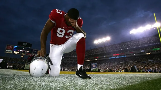 Calais Campbell #93 of the Arizona Cardinals kneels on the field before taking on the Pittsburgh Steelers during Super Bowl XLIII on February 1, 2009. (Source: Al Bello/Getty Images)