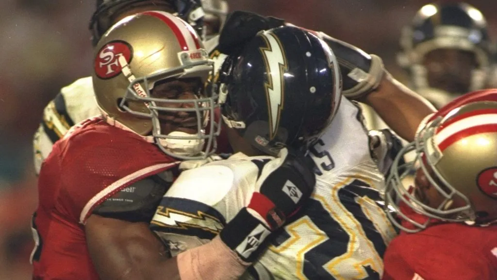 Running back Natrone Means #20 of the San Diego Chargers is tackled by several San Francisco 49ers players during Super Bowl XXIX in 1995. (Source: Simon Bruty /Allsports)