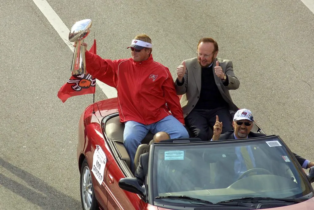 TAMPA, FL – JANUARY 28:  Former head coach Jon Gruden of the Tampa Bay Buccaneers rides with team Owner/President Malcolm Glazer during a victory parade on January 28, 2003 in Tampa, Florida. The Buccaneers defeated the Oakland Raiders 48-21 in Super Bowl XXXVII. (Photo by Chris Livingston/Getty Images)