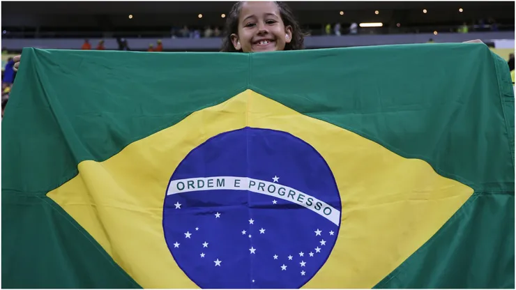 A young fan of Brazil cheers with the Brazilian flag