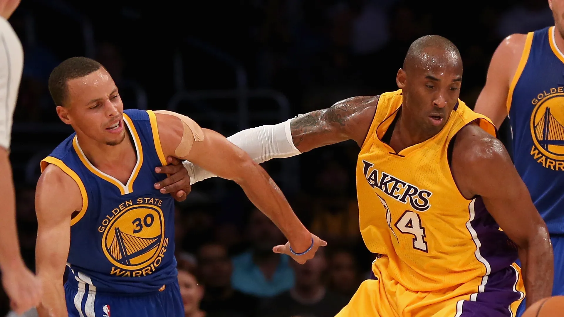 Kobe Bryant #24 of the Los Angeles Lakers drives down the court after stealing the ball from Stephen Curry (L) #30 of the Golden State Warriors