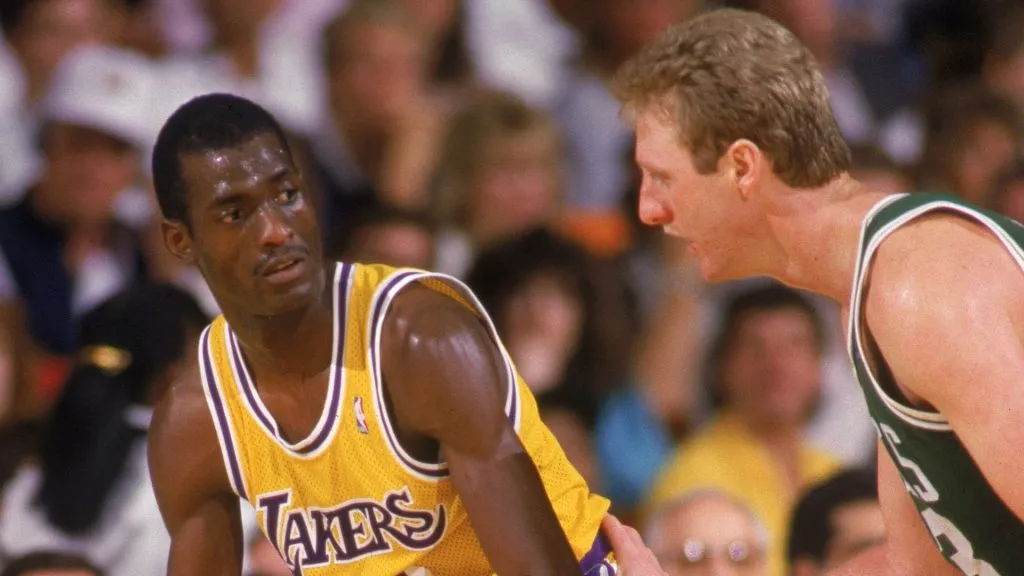 Michael Cooper #21 of the Los Angeles Lakers looks to pass over Larry Bird #33 of the Boston Celtics during an NBA game