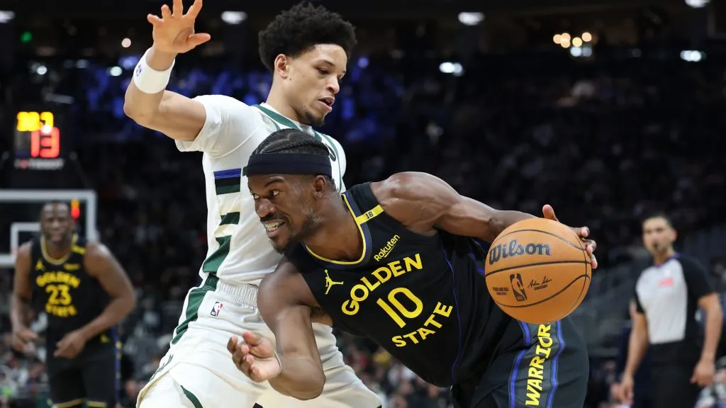 Jimmy Butler #10 of the Golden State Warriors drives around Ryan Rollins #13 of the Milwaukee Bucks during the first half of a game at Fiserv Forum. (Stacy Revere/Getty Images)
