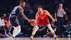 Damian Lillard #0 of the Milwaukee Bucks dribbles the ball against Stephen Curry #30 of the Golden State Warriors in the third quarter during the 2024 NBA All-Star Game.