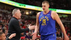 Nikola Jokic of the Denver Nuggets high fives head coach Michael Malone on December 12, 2023.