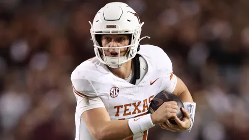 Arch Manning #16 of the Texas Longhorns scrambles in the first half against the Texas A&M Aggies at Kyle Field on November 30, 2024 in College Station, Texas.