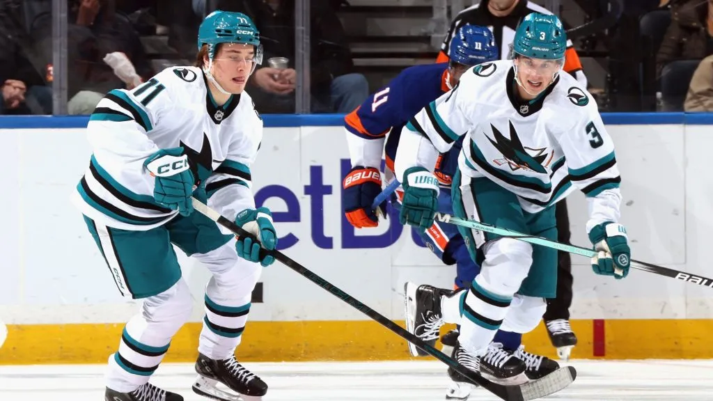 Macklin Celebrini #71 and Henry Thrun #3 of the San Jose Sharks skate against the New York Islanders at UBS Arena on January 18, 2025. (Source: Bruce Bennett/Getty Images)
