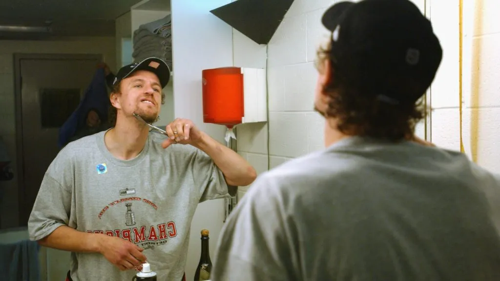 Fredrik Olausson of the Detroit Red Wings shaves his beard in the locker-room after defeating the Carolina Hurricanes during game five of the NHL Stanley Cup Finals in 2002. (Source: Dave Sandford/Getty Images/NHLI)