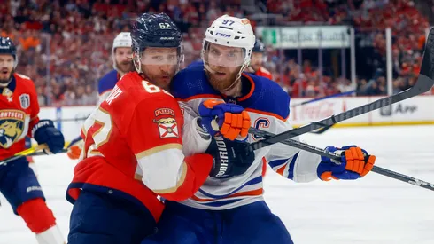 Brandon Montour #62 of the Florida Panthers and Connor McDavid #97 of the Edmonton Oilers battle during first period action in Game Seven of the Final of the 2024 Stanley Cup Playoffs.