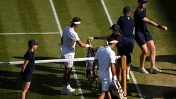 A ball kid passes a towel to Rafael Nadal as he and Roger Federer of Switzerland walk back to their chairs before a change of serve in their Men's Singles semi-final match against Roger Federer in 2019.